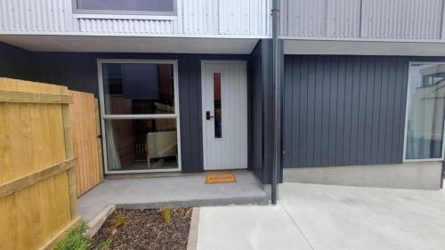 a front door of a house with a door gmaxwell gmaxwell gmaxwell at Modern trendy style & comfort in Dunedin