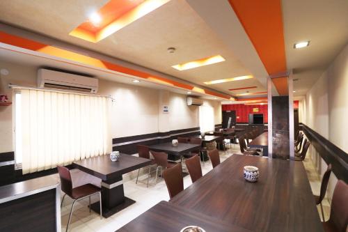 a restaurant with tables and chairs in a room at Hotel O Sonu in Tarapith