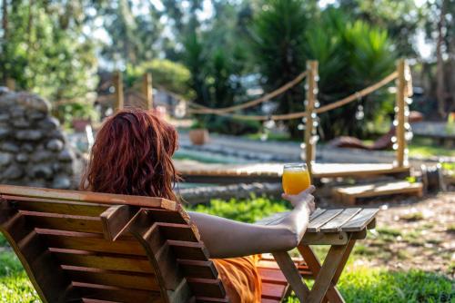 a woman sitting in a chair holding a glass of orange juice at Bosques del Paico in El Monte