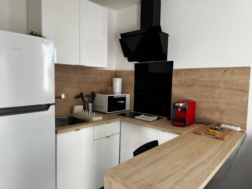 Il comprend une cuisine équipée d'un réfrigérateur et d'une table avec un four micro-ondes. dans l'établissement Le Coin Du Soleil, à Toulon