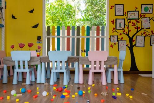 a table and chairs in a room with a fence at Cocoon Maldives - All Inclusive in Lhaviyani Atoll