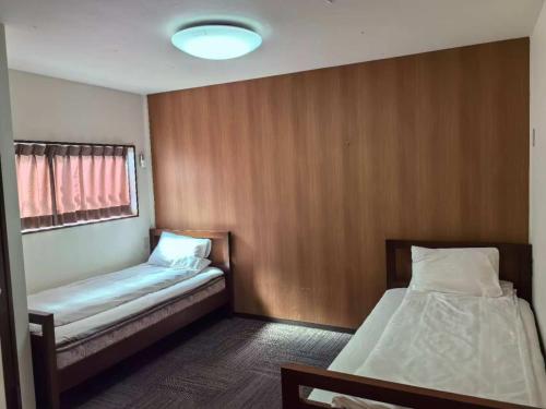 a room with two beds and a window at ホステル今鶴 二人部屋 302号室 in Osaka
