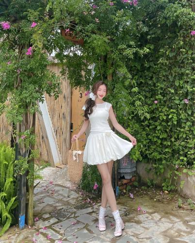 a woman in a white dress standing in a garden at LayLa Homestay in Lạc Dương