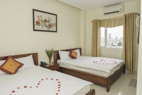 a hotel room with two beds and a window at Smile hotel in Da Nang