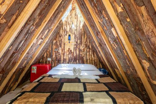 a bed in a room with a wooden wall at Bosques del Paico in El Monte