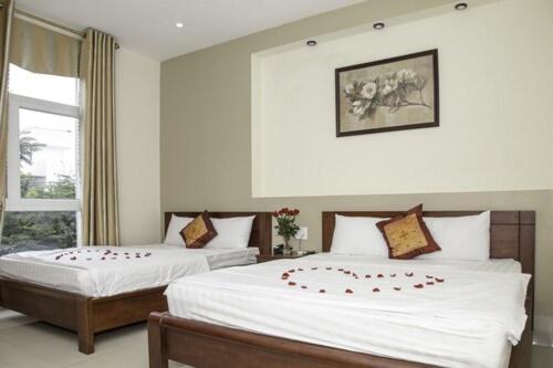 a bedroom with two beds with roses on them at Smile hotel in Da Nang