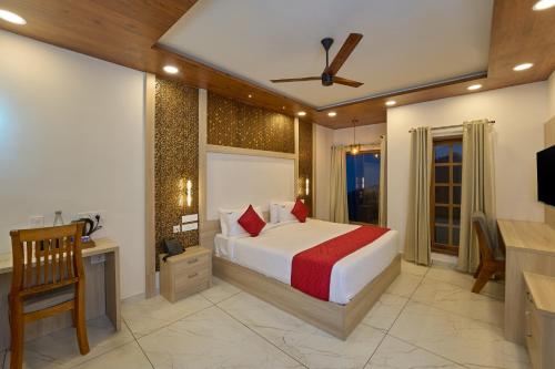 a bedroom with a bed and a desk and a television at The Planet Munnar in Suryanelli