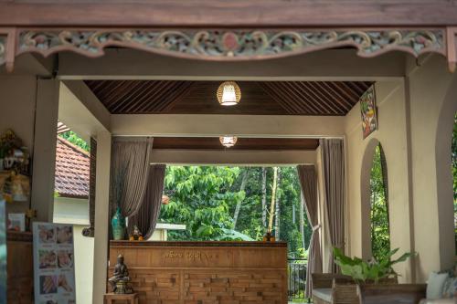 a room with a large window with a wooden door at Abhirama Villas and Spa in Ubud