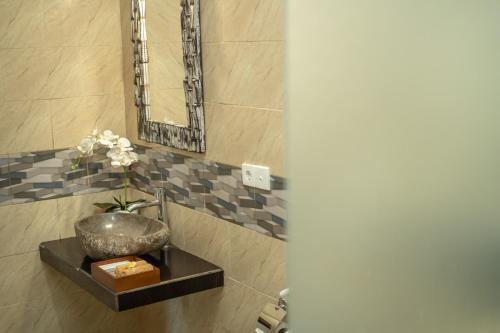a bathroom with a sink and a bowl on a shelf at Abhirama Villas and Spa in Ubud