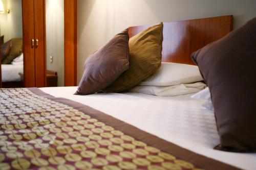 a close up of a bed with pillows at Best Western Plus Pinewood Manchester Airport-Wilmslow Hotel in Handforth