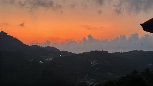 a sunset over a city with trees and clouds at Top Notch View Villa in Koh Tao