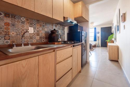 a kitchen with wooden cabinets and a sink at The art apartment in San Miguel de Allende