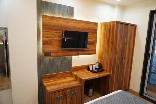 a room with a bed and a tv on a wall at Hotel De Grand Dwarka-Near Jaipur Airport in Jaipur