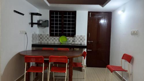 a kitchen with a wooden table and red chairs at Vagamon Hill On Misty Private villa2BHK in Vagamon