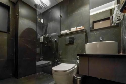 a bathroom with a toilet and a shower and a sink at ila comfort in Bāglung