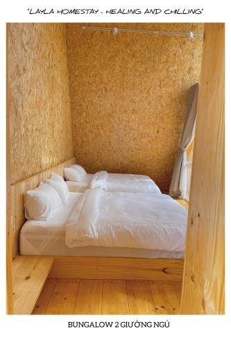 a bedroom with a bed with white sheets and pillows at LayLa Homestay in Lạc Dương
