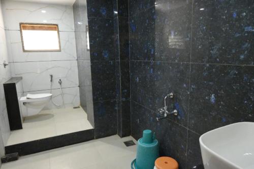 a bathroom with a shower with a toilet and a sink at Hotel Roshan Palace in Ambaji