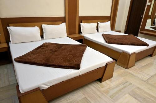 two beds sitting in a room with at Hotel Roshan Palace in Ambaji
