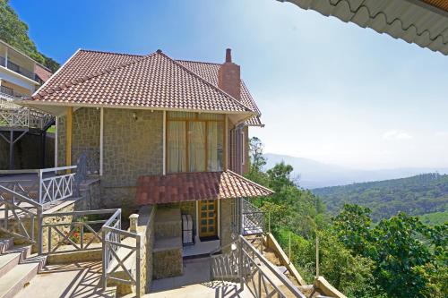 a house with a balcony with a view at The Planet Munnar in Suryanelli