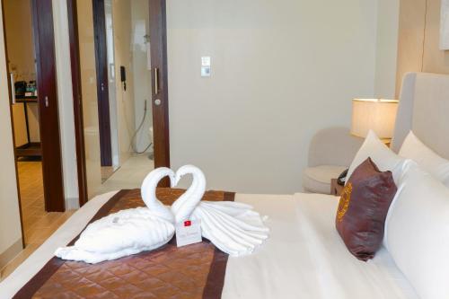 two swans made out of towels on a bed at Grand Westside Manila Bay in Manila