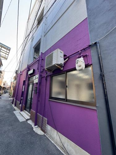 a purple wall of a building with a window at ホステル今鶴 二人部屋 402号室 in Osaka