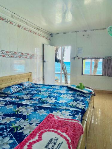 a bedroom with a bed with a blue and white blanket at Đảo Bình Ba,view biển, không nhận khách quốc tế, phòng đôi - nhận cọc trước mới giữ phòng in Ấp Binh Ba