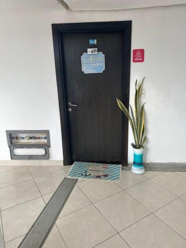 Eine schwarze Tür mit einem Schild neben einer Pflanze. in der Unterkunft Ocean Suites 1 Exceptional frente al mar in Playas