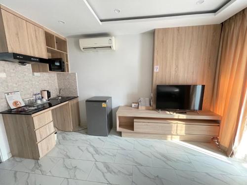 a room with a kitchen with a tv and a counter at D Eco Wellness Center in North Pattaya