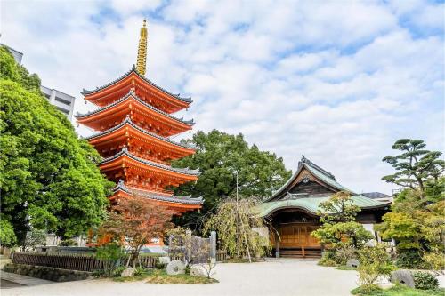 a large orange pagoda in front of a building at goom Hotel Nakasu in Fukuoka