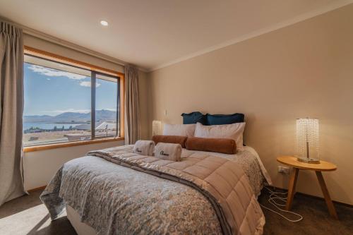 a bedroom with a large bed with a large window at Lake Lodge Tekapo in Lake Tekapo