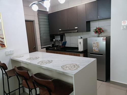 a kitchen with a counter with chairs and a refrigerator at Raycation Homestay in Johor Bahru