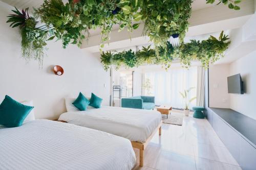 two beds in a room with plants hanging from the ceilings at Sukumo -蒅- in Tokyo