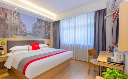 a hotel room with a large bed and a desk at Junyi Hotel - Zaozhuang High Speed Railway Station in Taozhuang