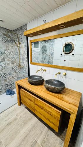 deux lavabos sur un comptoir en bois dans une salle de bain dans l'établissement Maison de la Presqu'île - 4 chambres avec Vue Mer, à Lanmodez