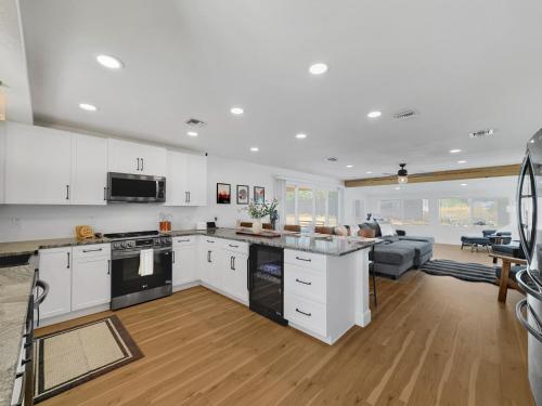 a kitchen with white cabinets and a living room at Boulder Apache Junction in Apache Junction