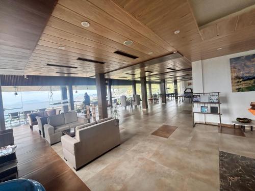 a living room with couches and tables in a building at Staycation Premium Mud House with Balcony Mashobra - A Nature Retreat in Shimla