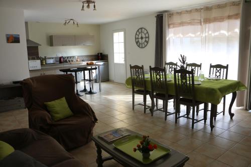 een woonkamer met een tafel en stoelen en een keuken bij Etape Cathare in Duilhac