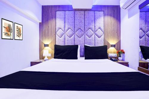 a bedroom with a large white bed and two lamps at Super Hotel O Sakinaka Andheri Kurla Road in Mumbai