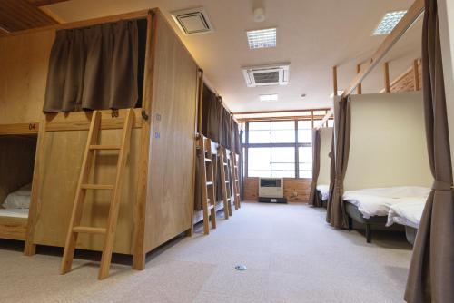 a room with bunk beds and a room with a ladder at 馬籠ふるさと学校 Magome Furusato Gakkou in Nakatsugawa