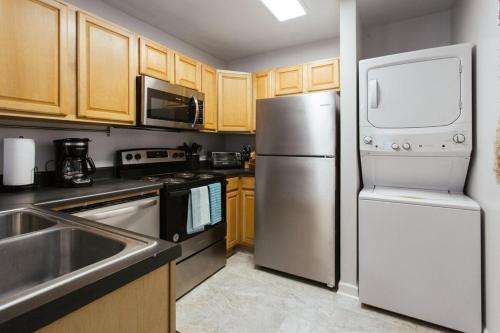 eine Küche mit Küchengeräten aus Edelstahl und Holzschränken in der Unterkunft The Cozy Corner Near Downtown 2Br in Athens