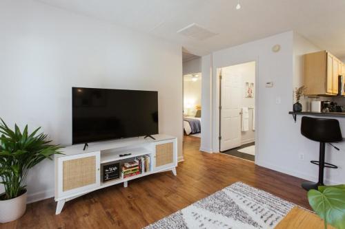 ein Wohnzimmer mit einem Flachbild-TV auf einem weißen Entertainment-Center in der Unterkunft The Cozy Corner Near Downtown 2Br in Athens