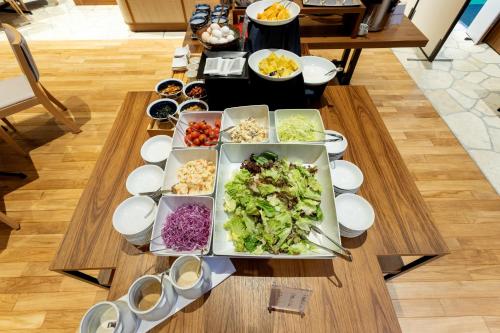 a table with a bunch of food on it at Hotel Sundays Amami in Amami