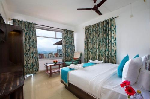 a bedroom with a bed and a window and a table at Lazo Golden Valley Resort , Munnar in Munnar