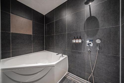 a bathroom with a white tub and a shower at Guwol Rondo Hotel in Incheon