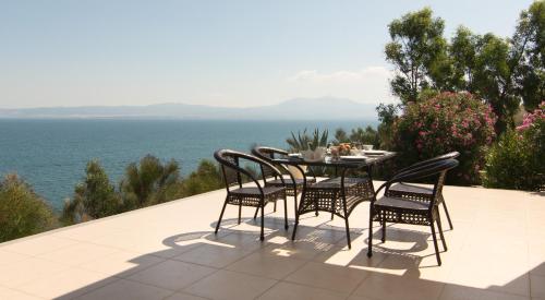 a table and chairs on a patio overlooking the ocean at Angelbay Bungalows in Agia Triada