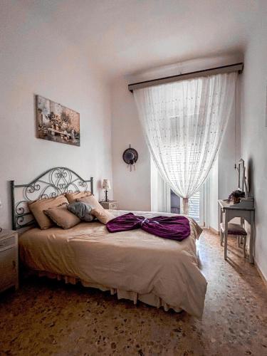 a bedroom with a large bed and a window at Casa della Lavanda Apartment in Oristano