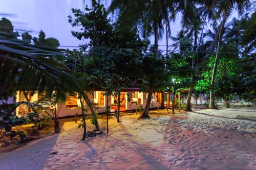a resort with trees in front of a building at Sea Hut Homestay in Cochin