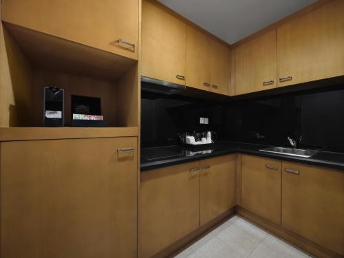 a kitchen with wooden cabinets and black counter tops at DoubleTree by Hilton Shanghai Pudong - Present welcome cookie in Shanghai