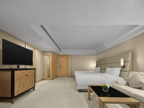a hotel room with a bed and a flat screen tv at DoubleTree by Hilton Shanghai Pudong - Present welcome cookie in Shanghai