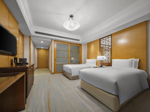 a hotel room with two beds and a flat screen tv at DoubleTree by Hilton Shanghai Pudong - Present welcome cookie in Shanghai